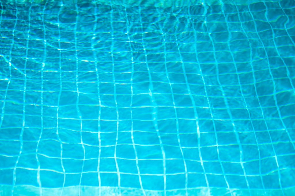 A pool water test kit with various test strips and chemicals is used for checking pool water quality.