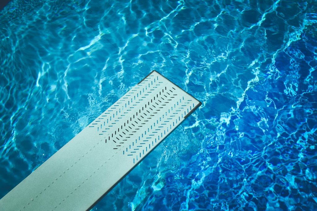 Using a pool water test kit to measure chlorine and pH levels in a swimming pool for proper maintenance.